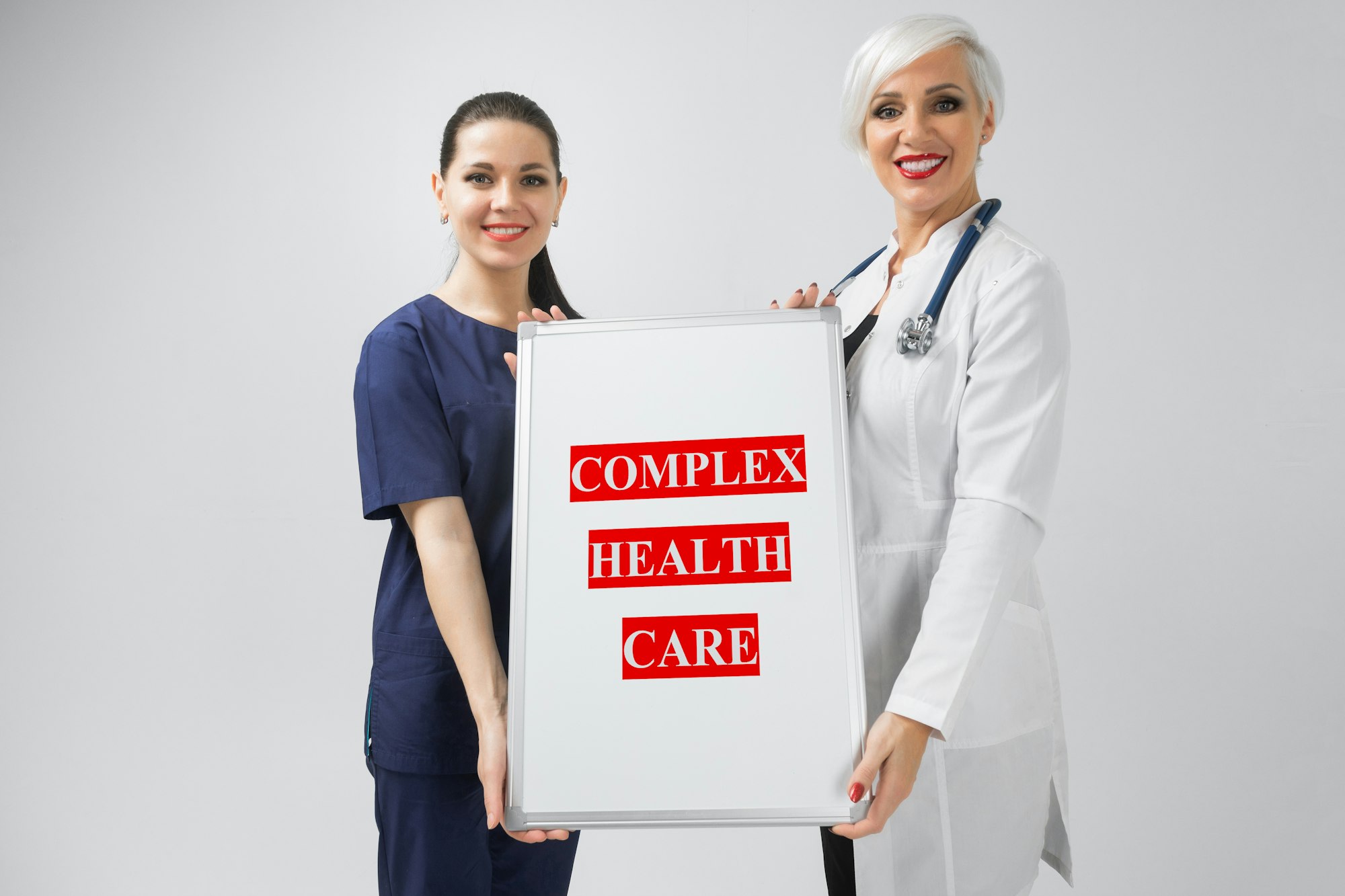 Doctor and nurse holding a poster with the inscription complex health care isolated on white