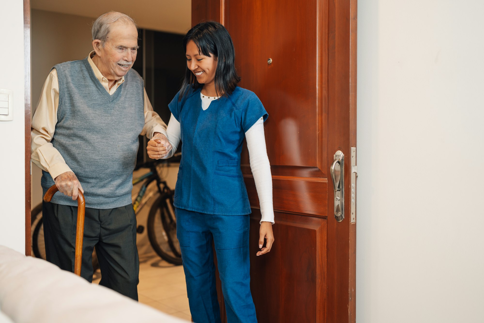 Old man assisted by a nurse during a home visit